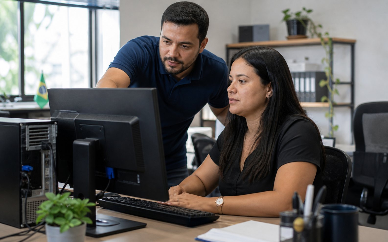 Especialista auxiliando uma profissional em seu computador — imagem ilustrativa